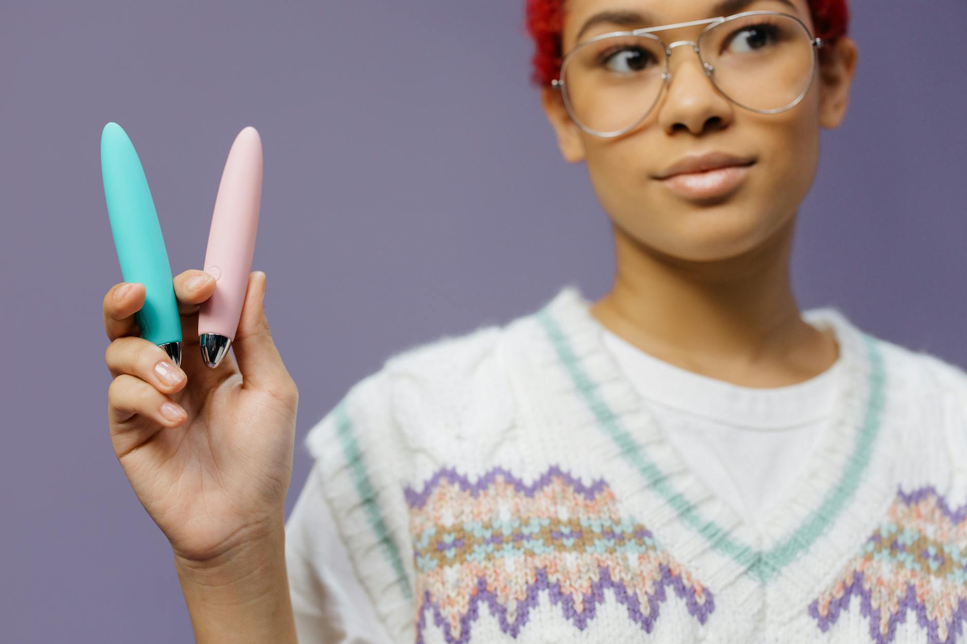 Donna che tiene in mano un vibratore clitorideo blu mentre riflette sul proprio piacere
