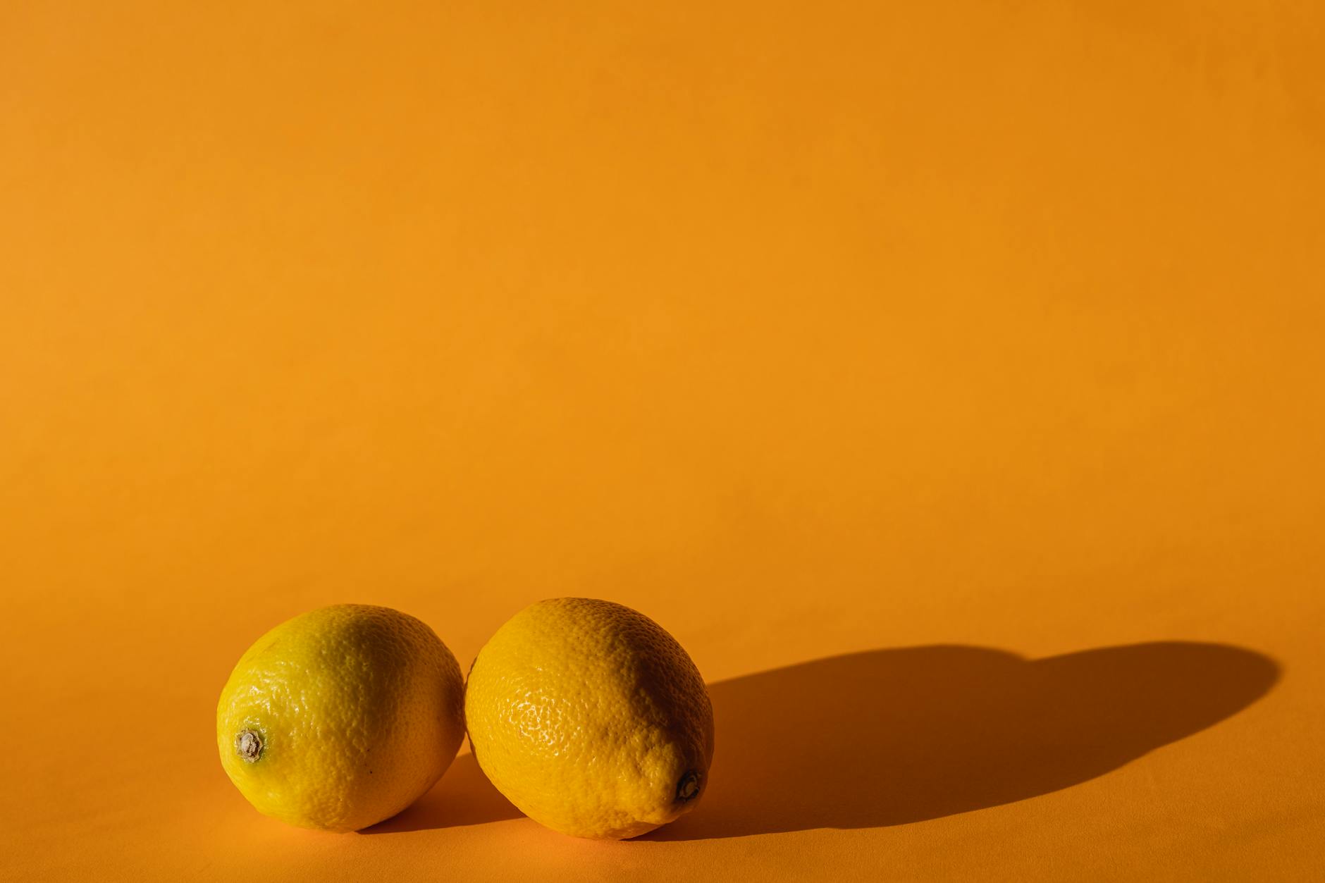 Bright yellow lemons arranged on a vibrant yellow background, symbolizing fresh approaches to pleasure recovery